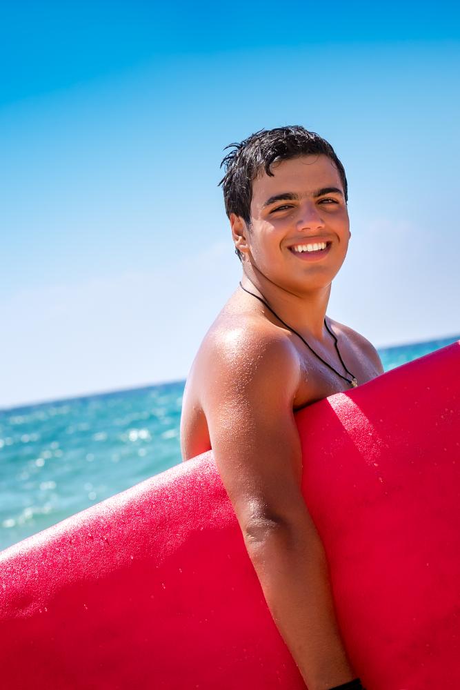 Portrait of a cheerful surfboarder embracing the spirit of lifeguarding