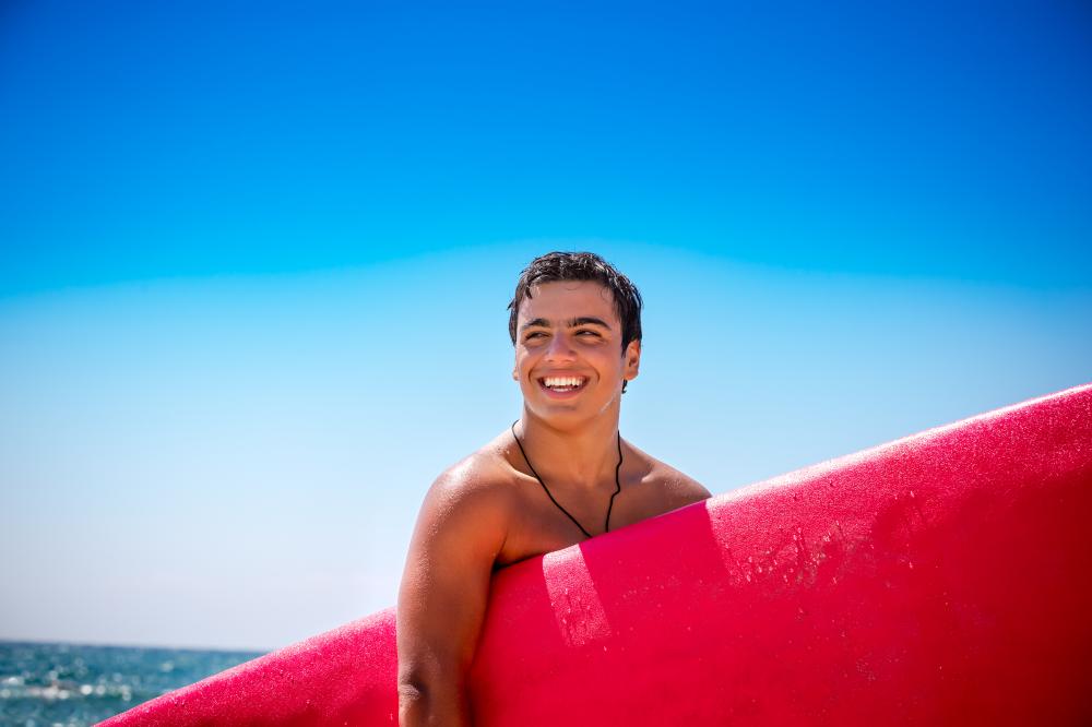 Happy boy enjoying surfing showcasing potential growth from lifeguard training