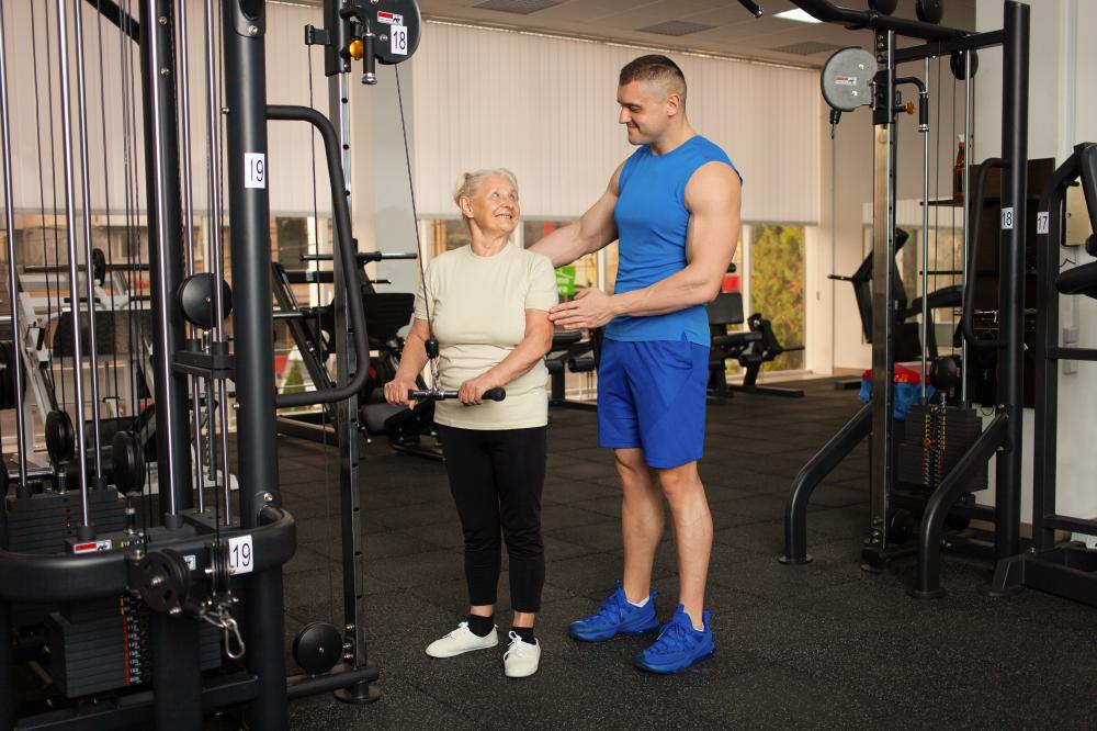 Professional coach assisting senior with exercise, showcasing personalized senior fitness  Gym Classes for Seniors NJ vecteezy young handsome coach man helps a pensioner to do an exercise 37150531 485