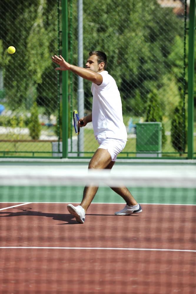 Young man playing pickleball outdoors