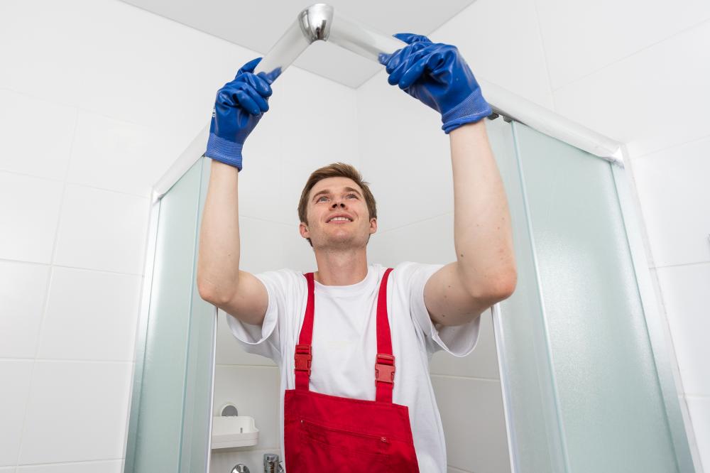 Diligent young plumber repairing a shower door, emphasizing emergency repair proficiency