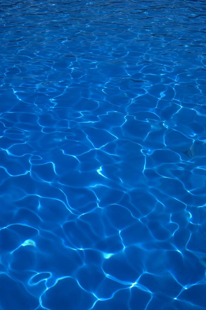 Crystal clear blue water in a heated swimming pool reflecting Palm Coast's sustainable living