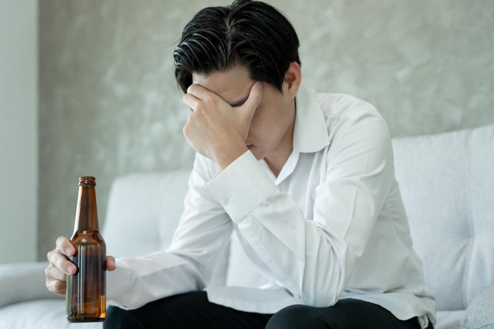 Depressed young businessman grappling with addiction in need of substance abuse treatment