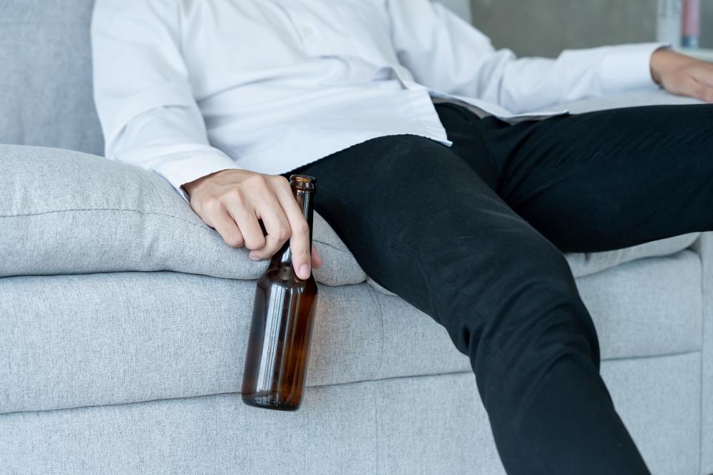 Young businessman struggling with alcohol addiction