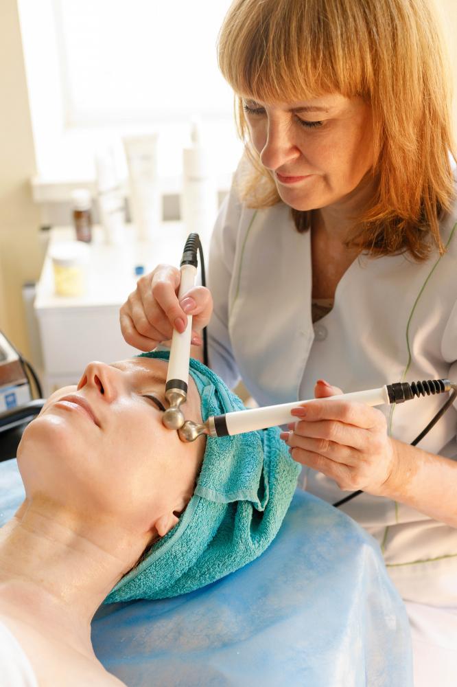Cosmetologist applying microcurrent therapy for facial rejuvenation