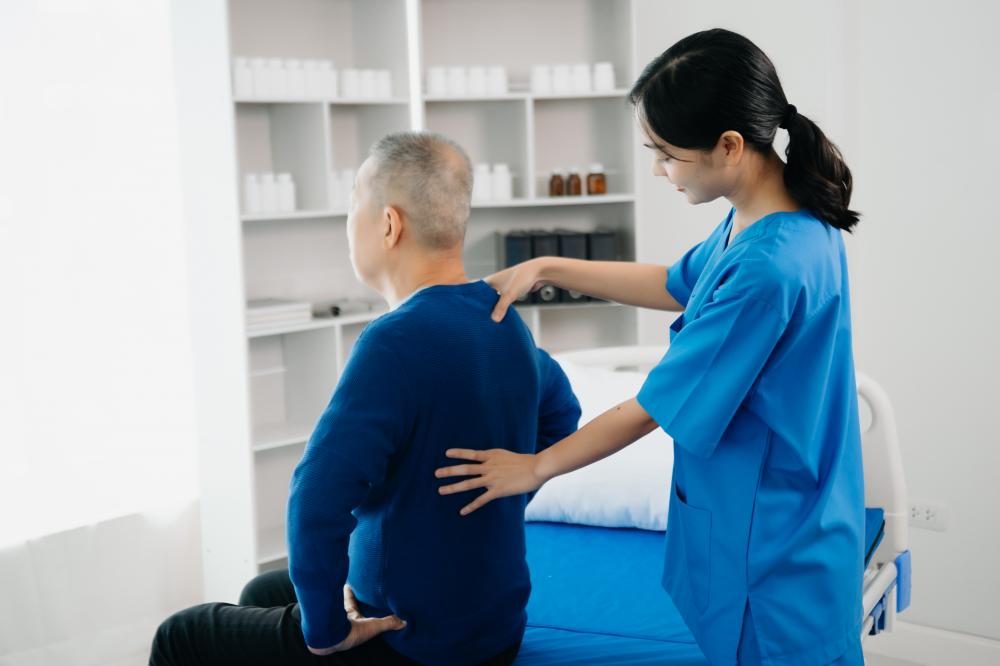 Chiropractor consulting with patient on back problems, enhancing Calgary Massage Therapy services