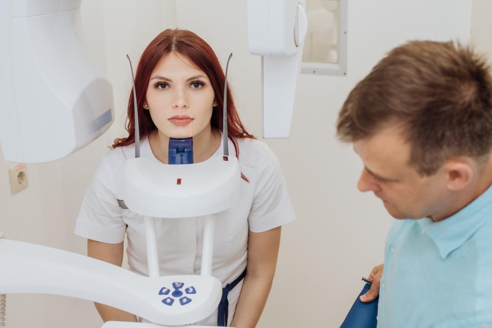 Patient receiving a panoramic dental X-ray for comprehensive cosmetic assessment