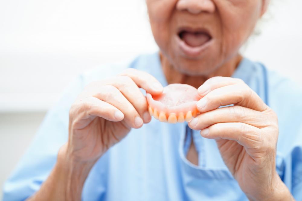 Asian senior woman patient trying on new dentures in Winter Haven, FL