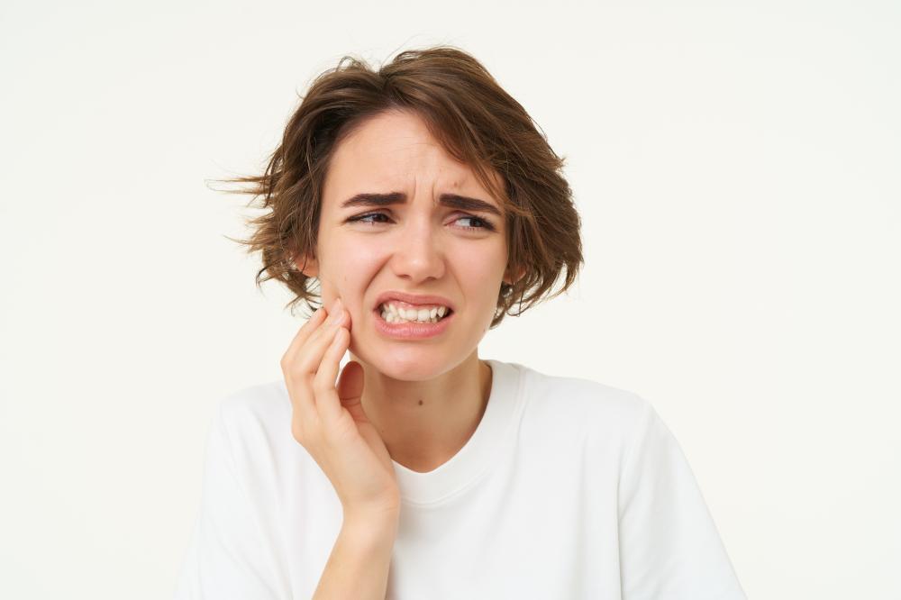 Woman with a toothache highlighting the need for an emergency dentist