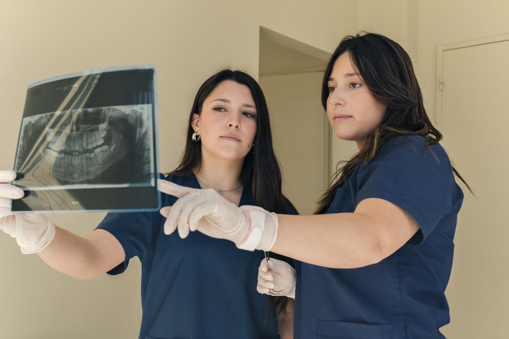 Dentist and assistant reviewing dental x-ray on a monitor