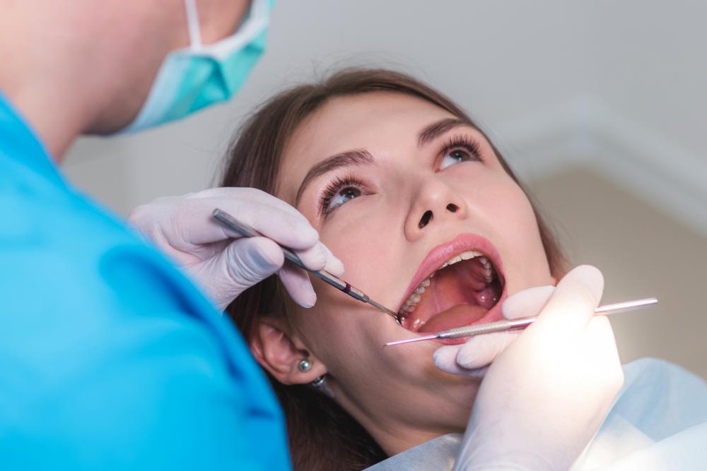 Orthodontist examining patient's oral cavity for emergency care