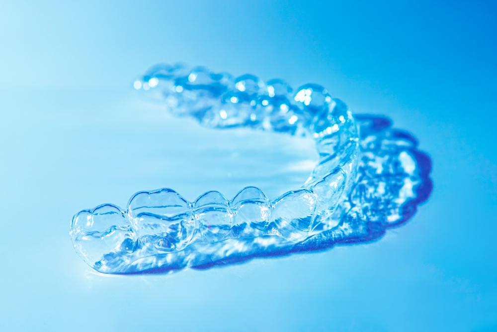 Invisalign clear aligners on a blue background, representing the invisible solution for straightening teeth