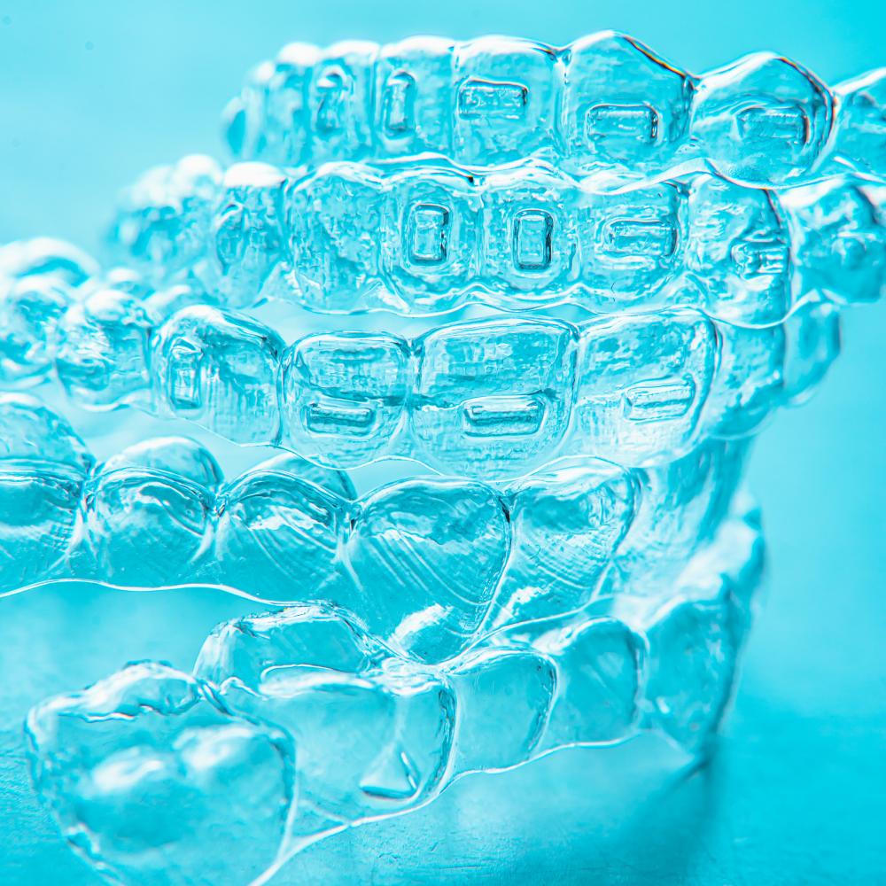 Vibrant display of Invisalign teeth brackets on turquoise background