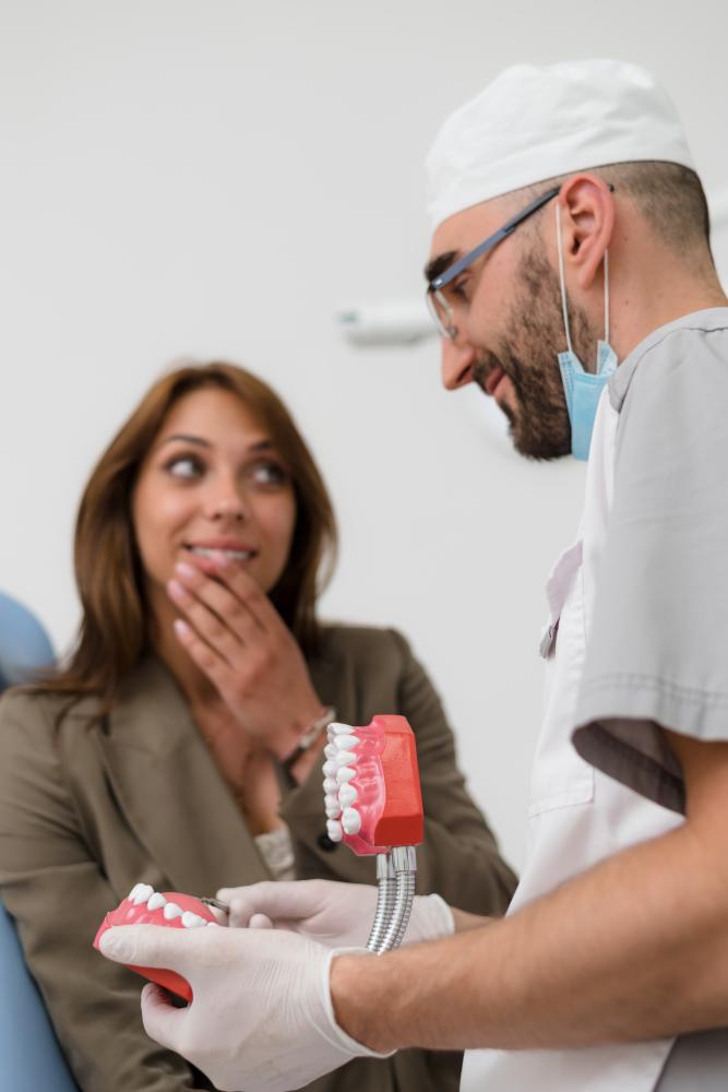 Dentist educating patient with jaw model