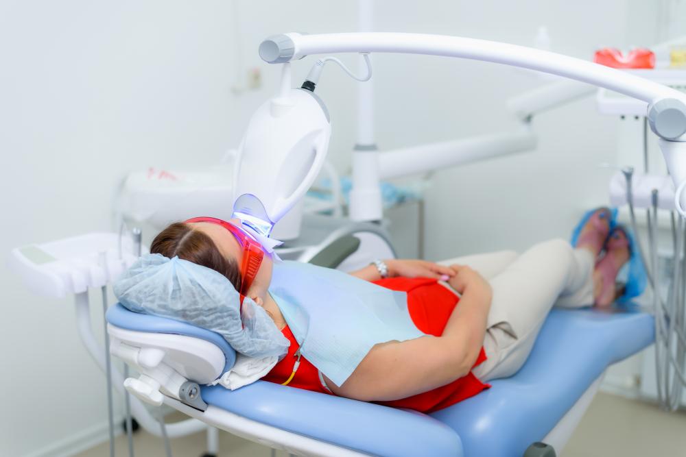 Patient undergoing teeth whitening procedure at dental clinic