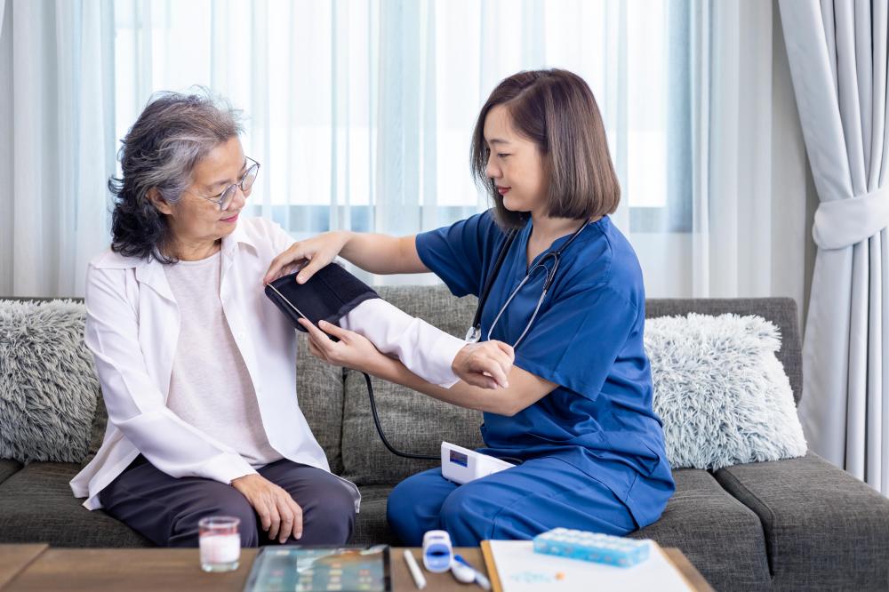 Caring nurse assisting an elderly woman in her NYC home