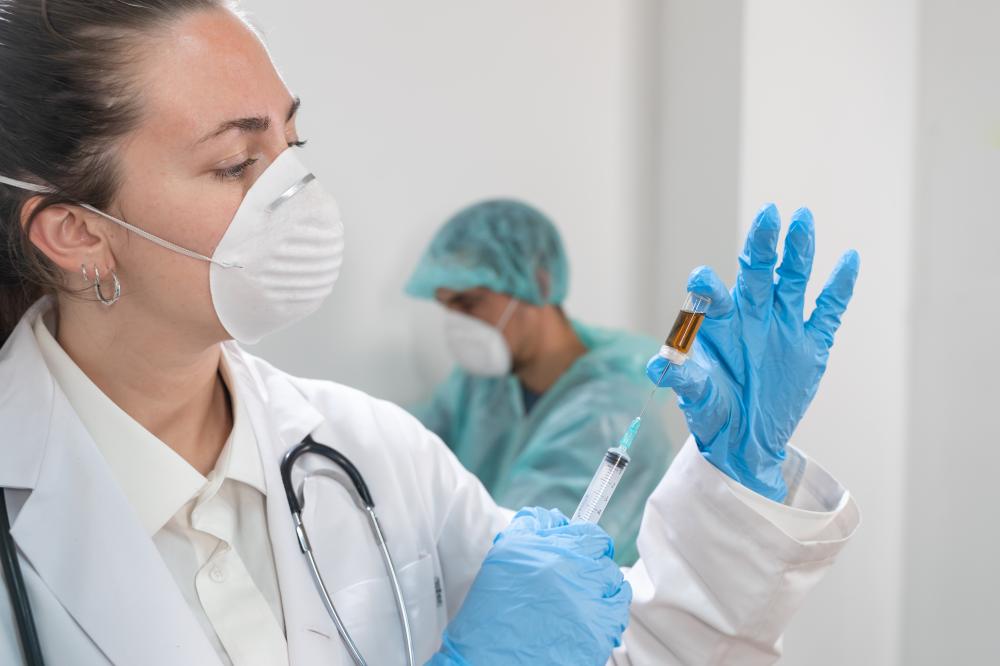 Female doctor preparing travel vaccine syringe for immunization