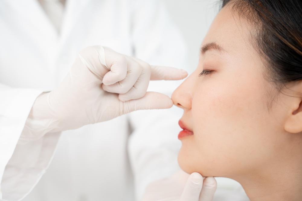 Expert beautician performing liquid rhinoplasty for facial balance
