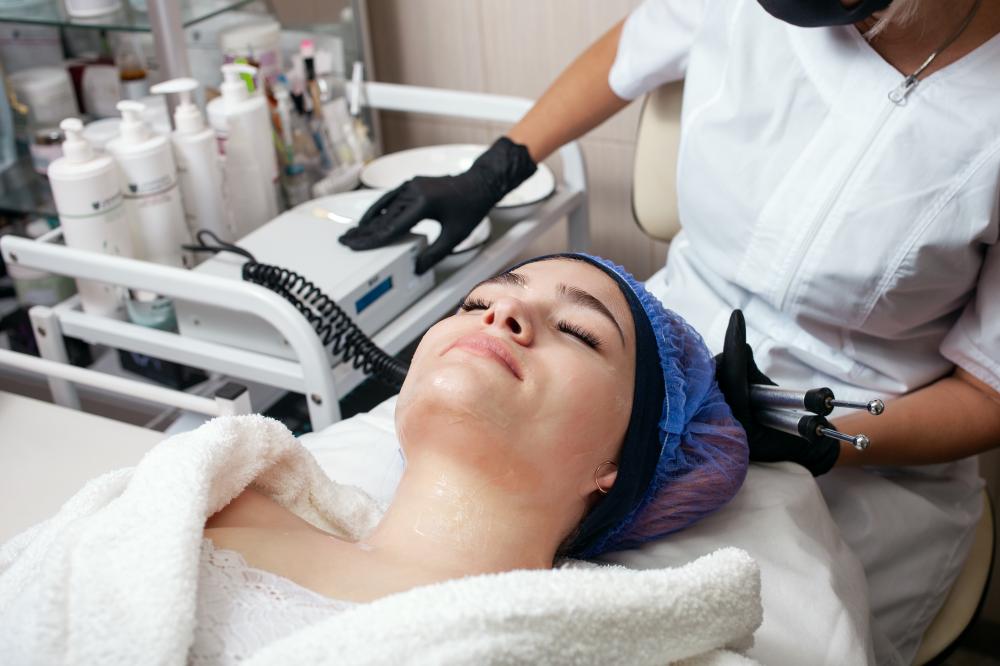 Beautician operating laser skin resurfacing equipment