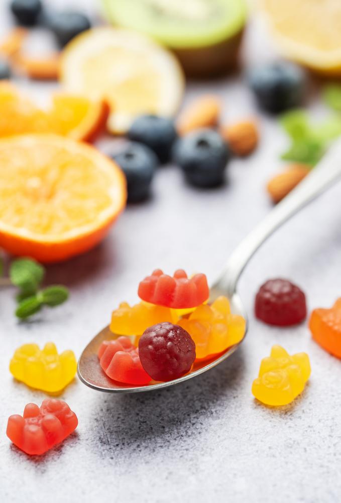 Chewable gummy vitamins alongside fresh fruits