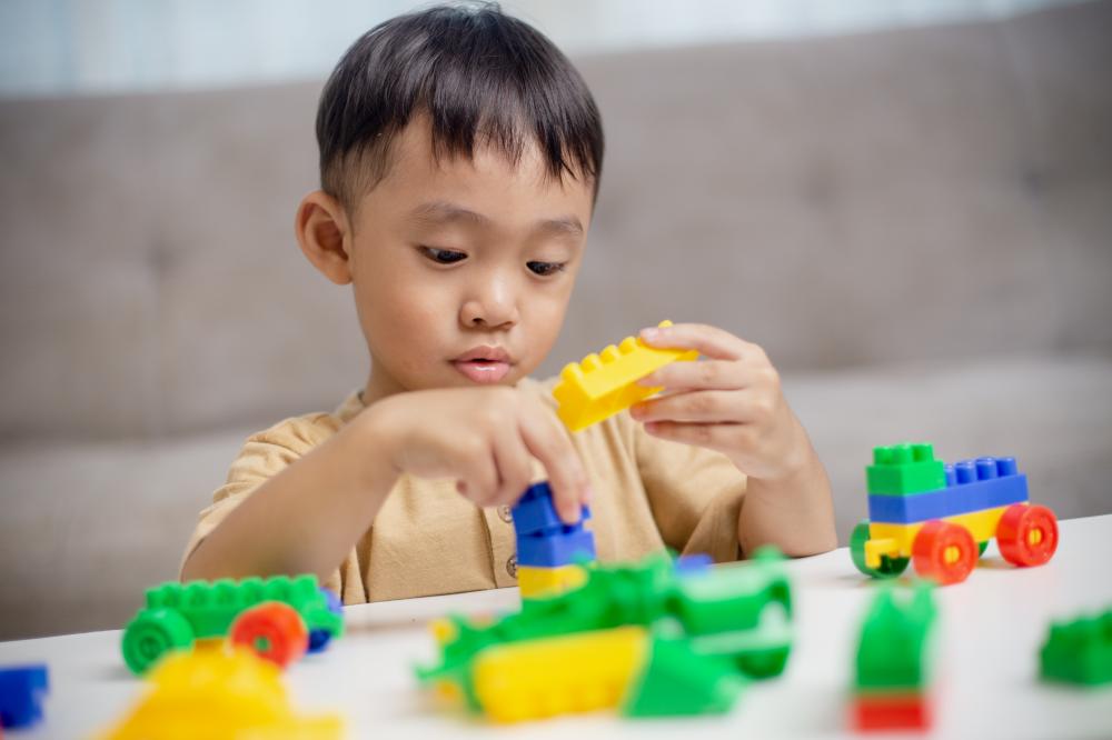 Little boy playing with colorful blocks, illustrating preschool engagement
