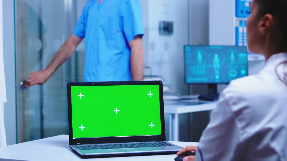Doctor using laptop with HIPAA compliant software at medical clinic