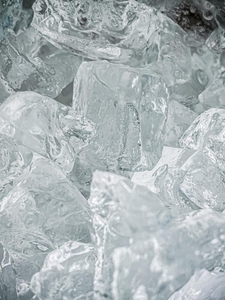 Close-up of clear ice cubes, highlighting texture and clarity, relevant to industrial ice production and maintenance.