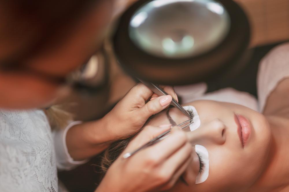 Focused lash artist applying extensions with precision