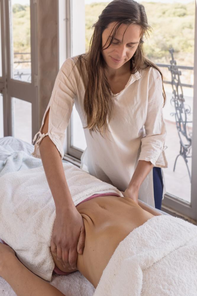 Woman receiving a therapeutic belly massage at a spa salon