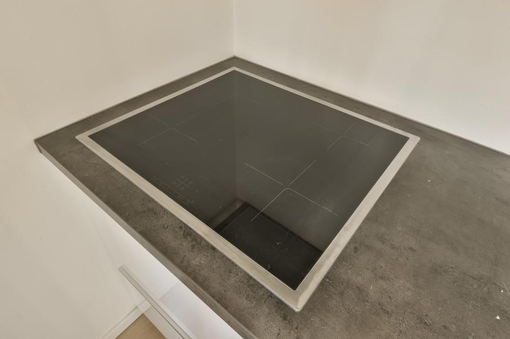 Thermador Freedom Induction Cooktop embedded in a sleek kitchen counter, showcasing a modern black surface with a stainless steel trim, ideal for efficient cooking.