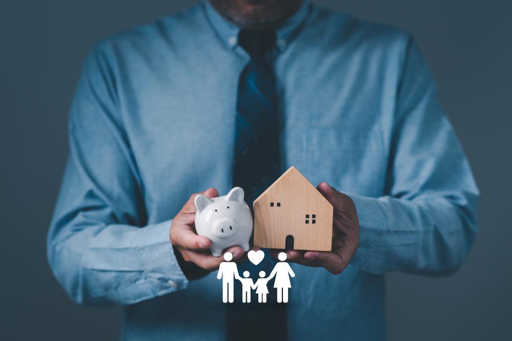 Businessman holding simulated wooden house and piggy bank highlighting Renters Insurance Toronto