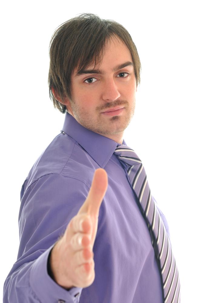 Business professional in a purple shirt and striped tie extending hand for a handshake, symbolizing collaboration and trust in SEO services.