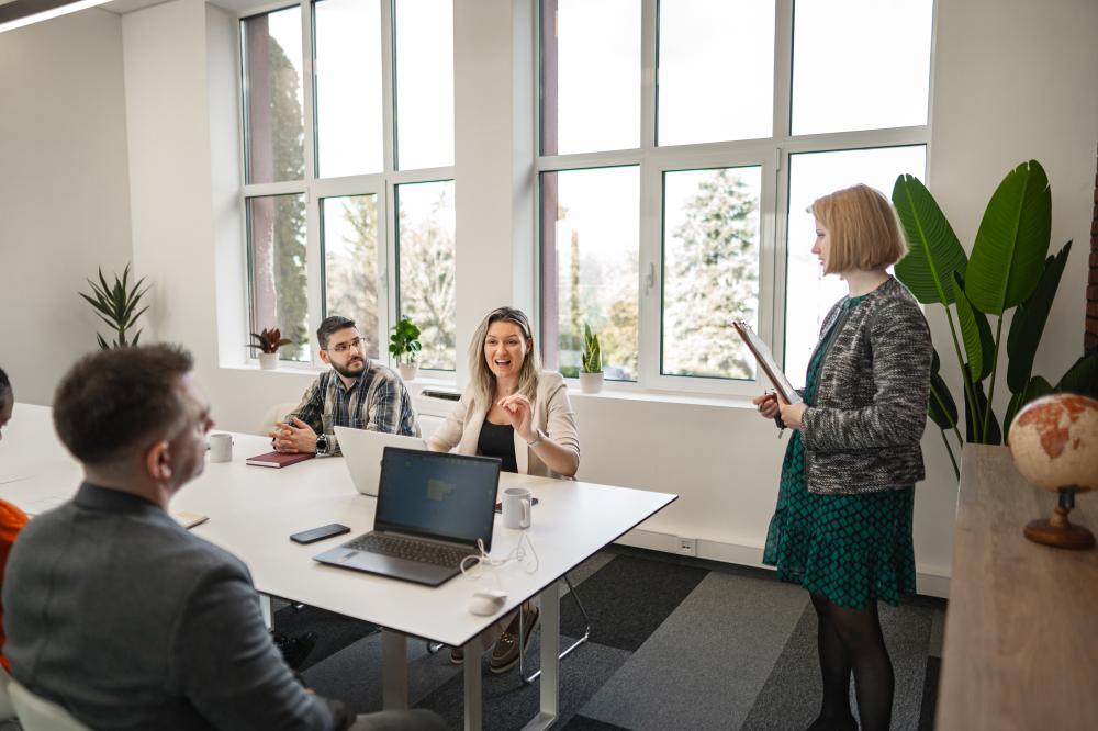 Group of professionals engaged in a meeting at Cloud 7 Agency, discussing digital marketing strategies with focus on client collaboration and communication.