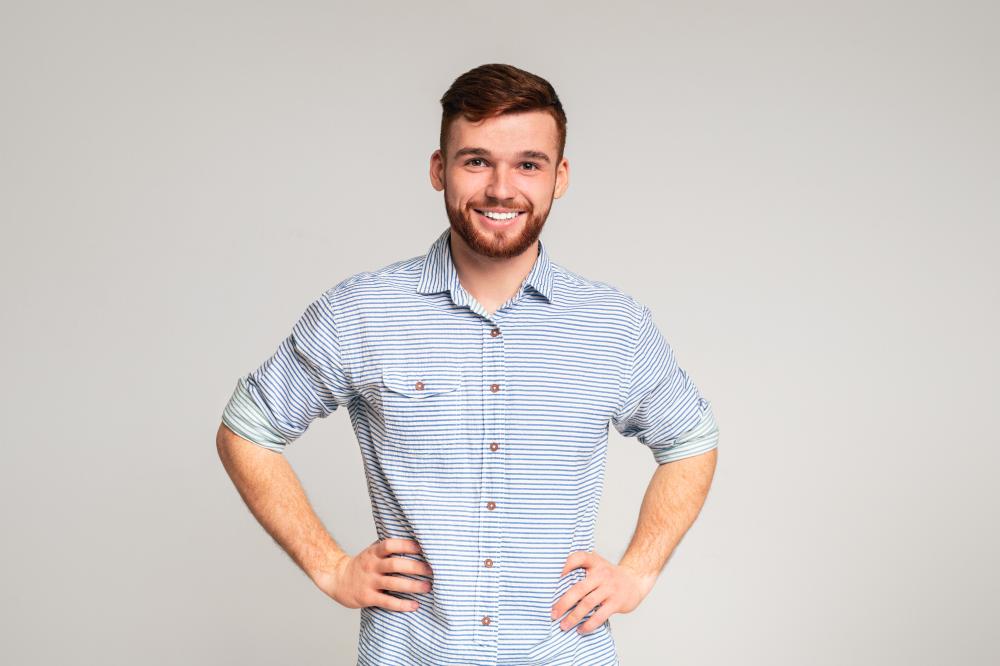 Smiling man in a striped shirt with hands on hips, representing confidence and approachability for SEO consulting in Salt Lake City.