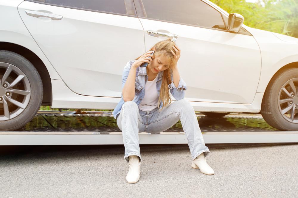 Young woman feeling sad in damaged car after an accident, highlighting the need for a Car Wreck Lawyer in West University Place
