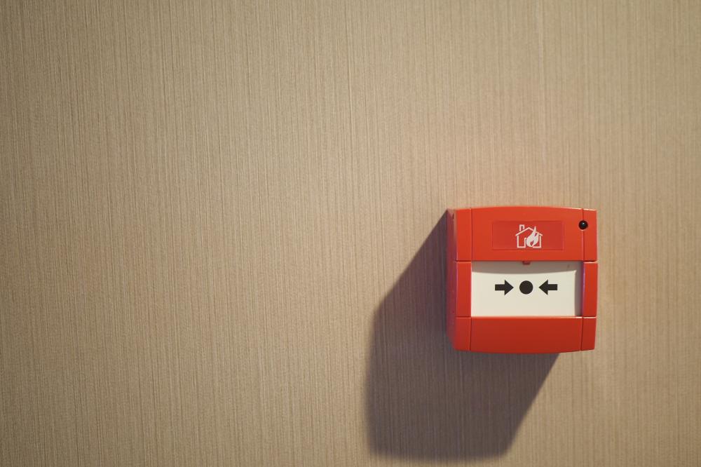 Urgent red fire alarm button on a commercial building wall